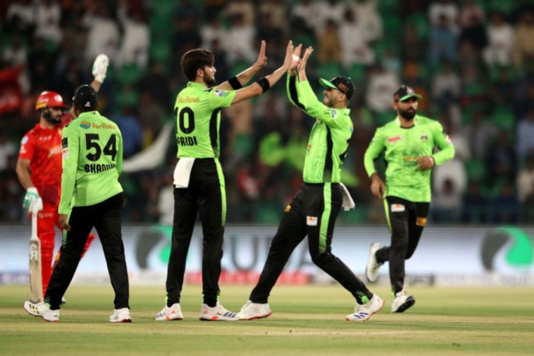 Lahore Qalanders players celebrated the wicket of Islamabad United player Muhammad Shahzad bowled by their teammate Shaheen Shah Afridi (C) during a Pakistan Super League T20