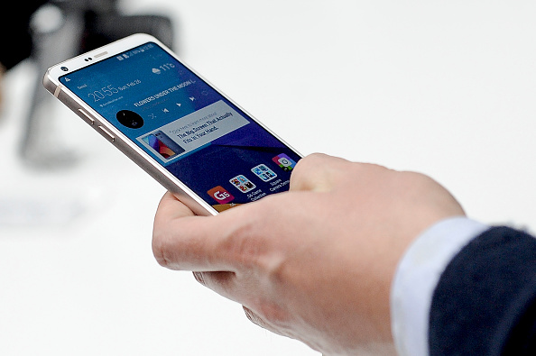 Person holding and using an LG G6 smartphone.