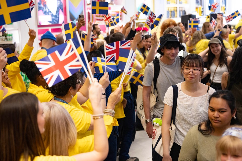 People holding British and Swedish flags in an IKEA store.