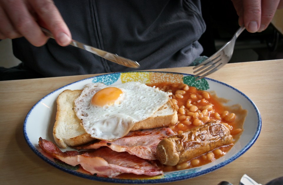 Person eating a full English breakfast.