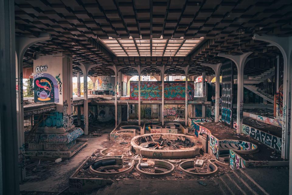 Sepia-toned photo of the graffiti-covered interior of the abandoned Haludovo Palace hotel.