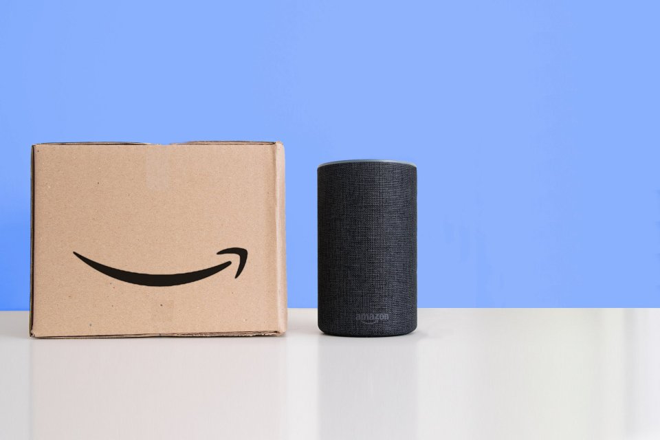 Amazon Echo smart speaker next to an Amazon package.