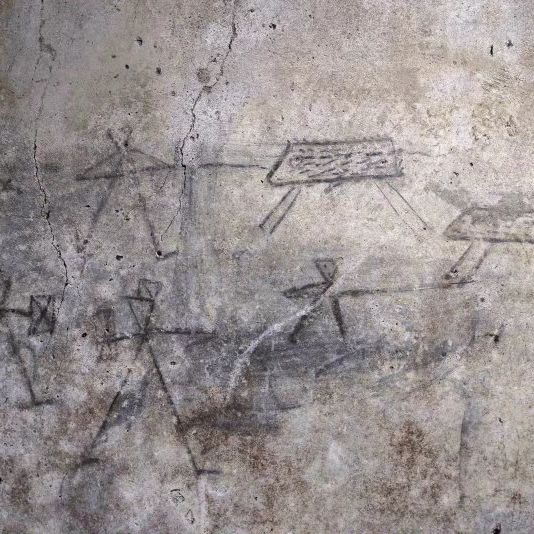 Ancient children's drawings of gladiators on a wall in Pompeii.