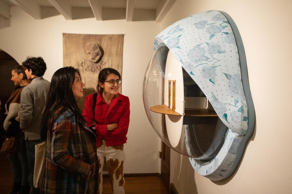 Art lovers view art pieces at an exhibition preview party/dinner.