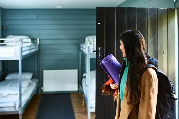 Mid adult woman with yoga mat entering yoga retreat accommodation, beginnings, anticipation, excitement
