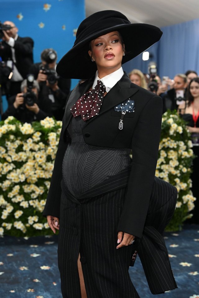 Rihanna at the Met Gala in a black pinstripe suit and wide-brimmed hat.