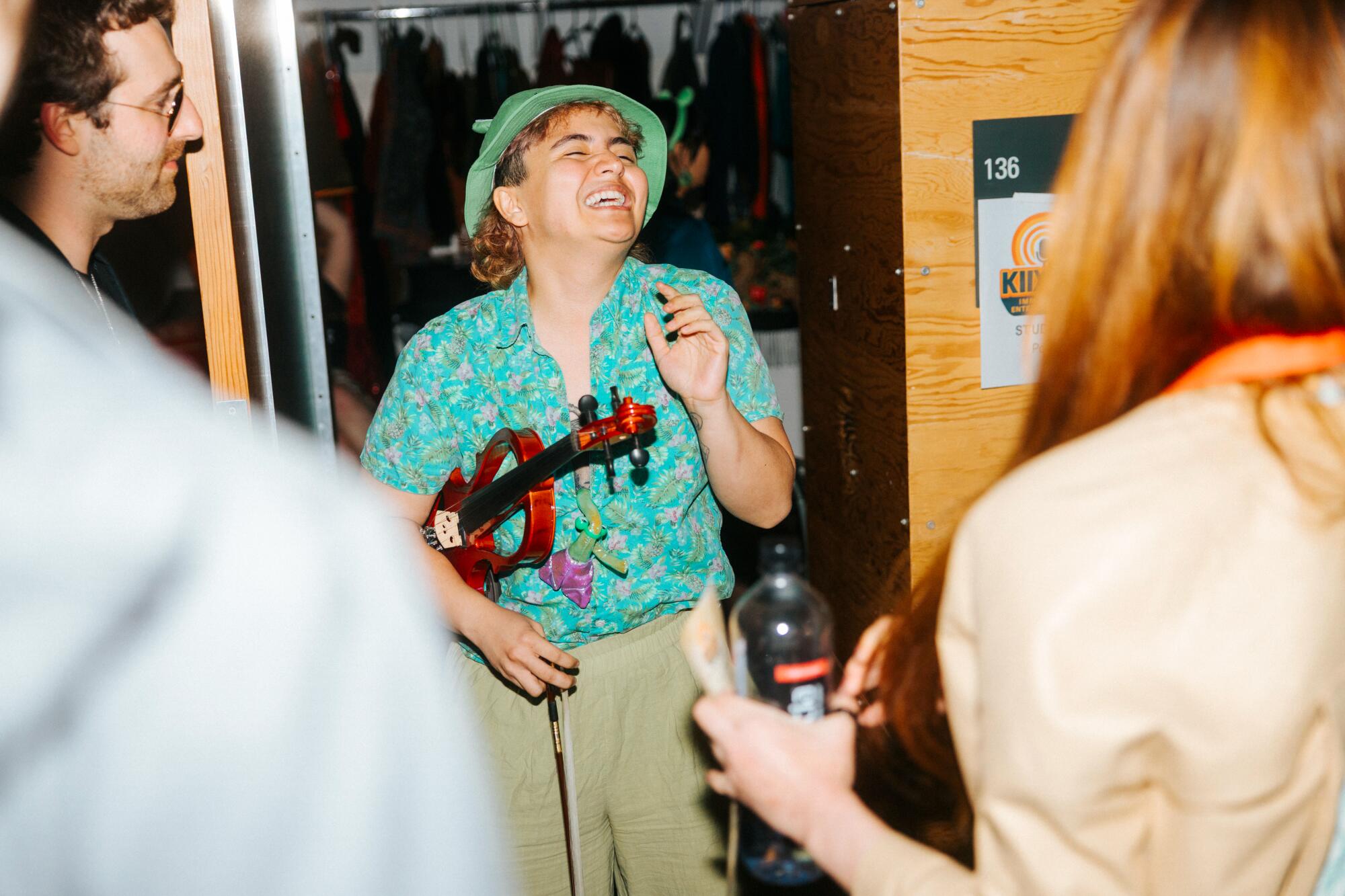 A person holds a stringed instrument as they sing.