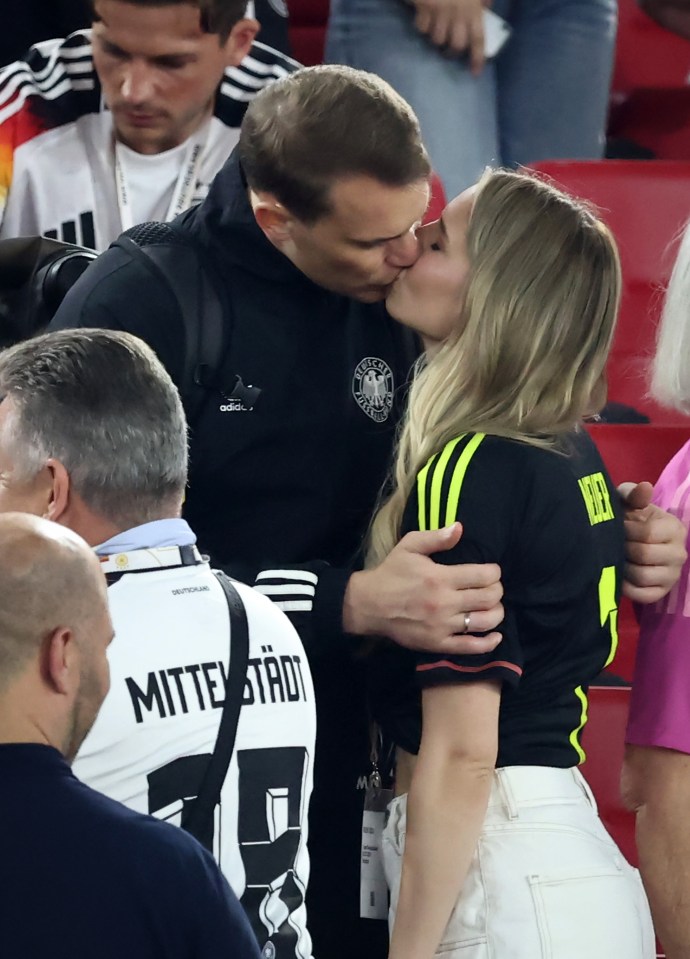 Manuel Neuer and his wife kissing after a soccer match.