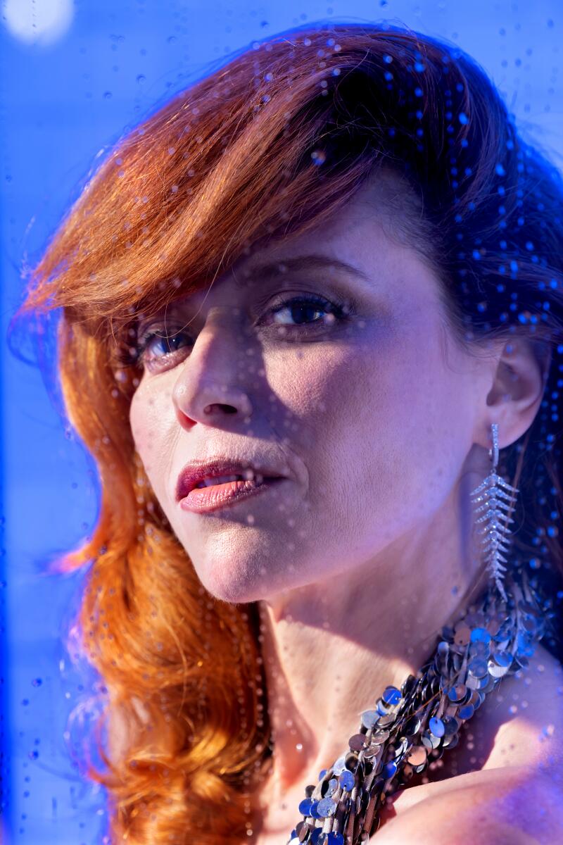 The face of a redheaded woman who has her face slightly turned toward the camera.