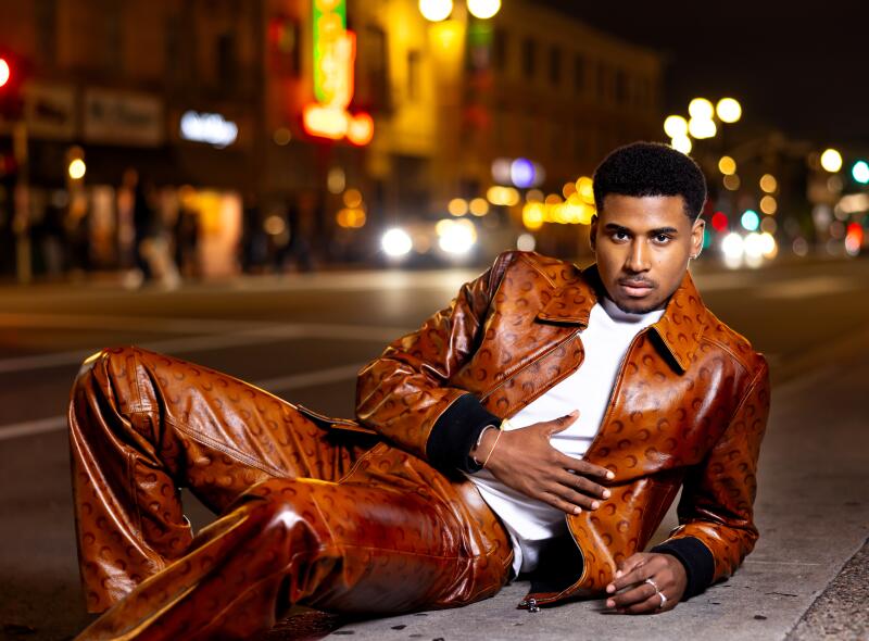 A man in a matching leather ensemble poses for a photo