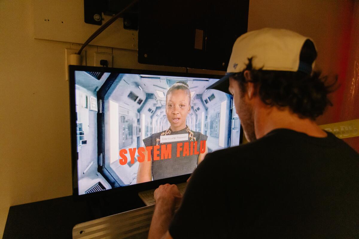 A guest in a ballcap interacts with a screen.