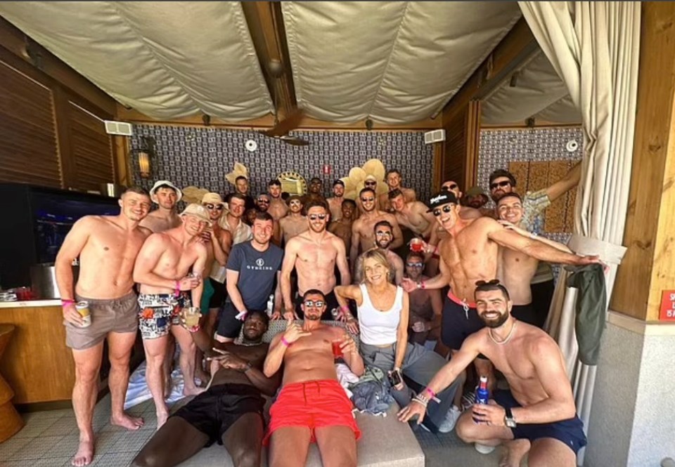 Large group of shirtless men and one woman at a pool party.