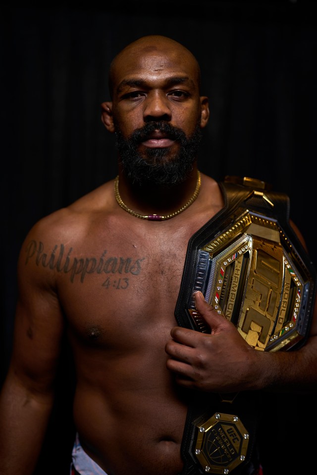 Portrait of Jon Jones holding a UFC championship belt.