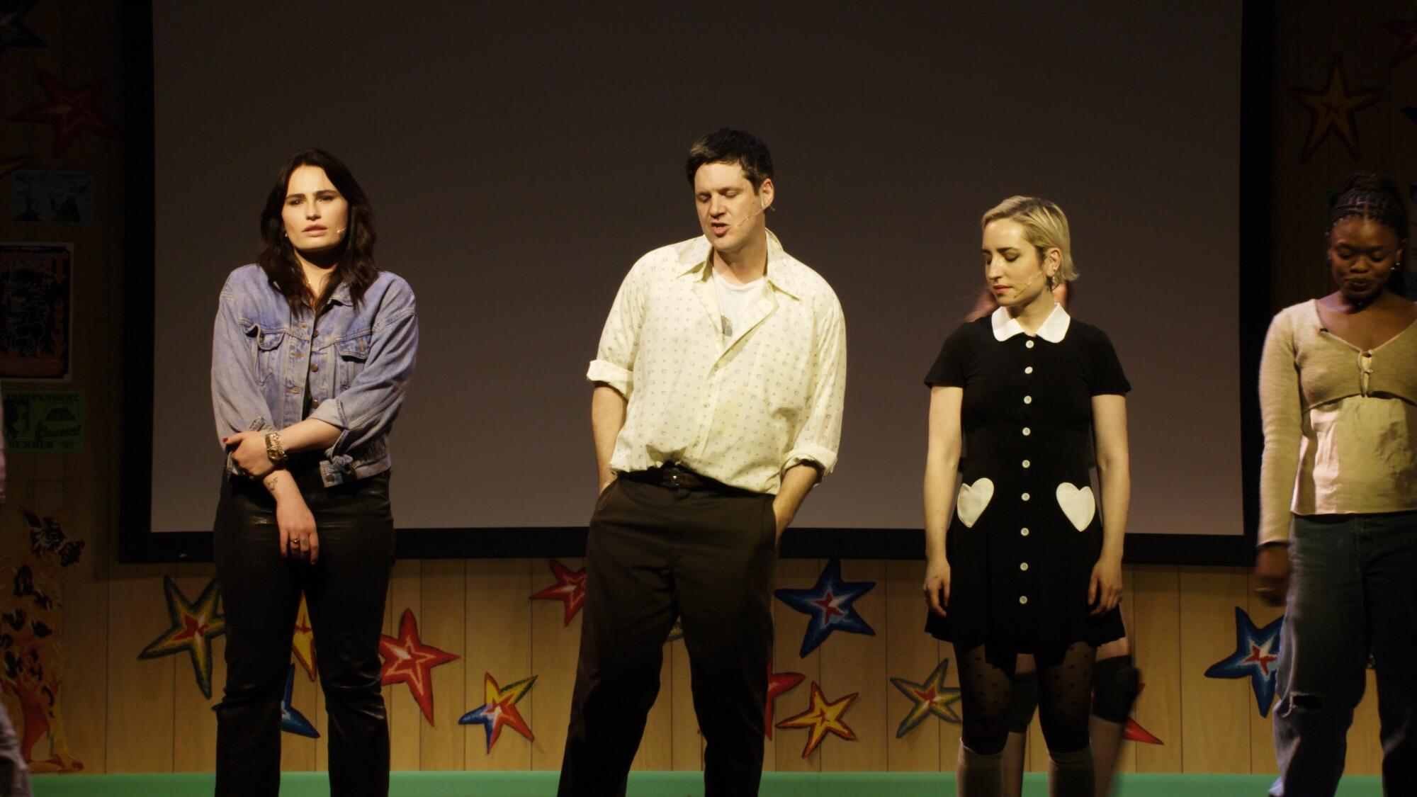 Three actors perform live on a stage.