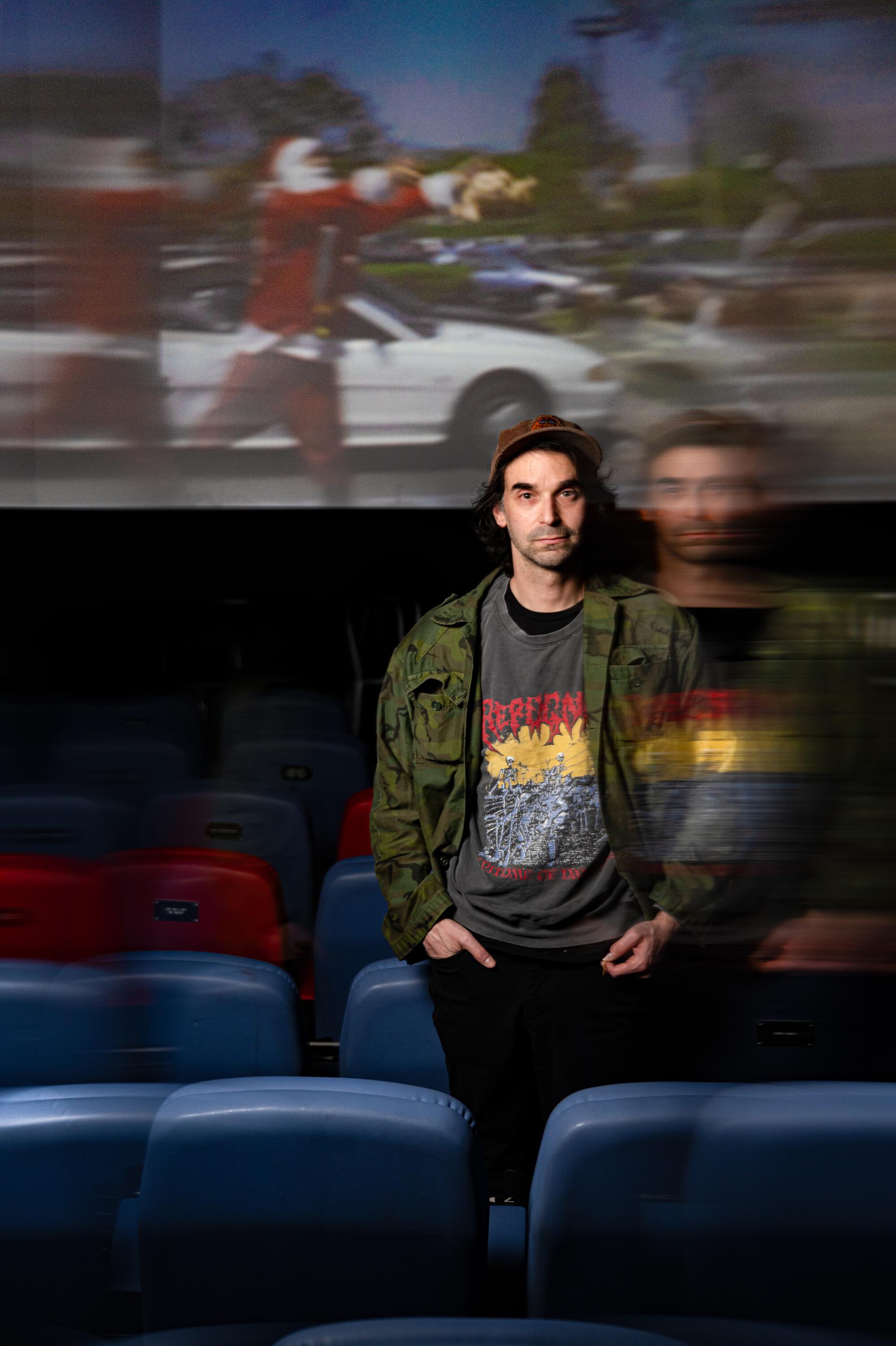 A director stands in an empty movie theater.