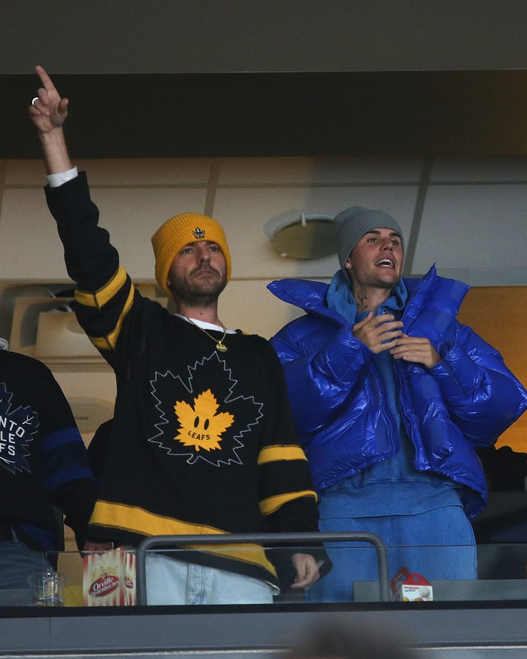 Justin Bieber and Ryan Good at a Toronto Maple Leafs hockey game wearing Drew House Leafs jerseys.
