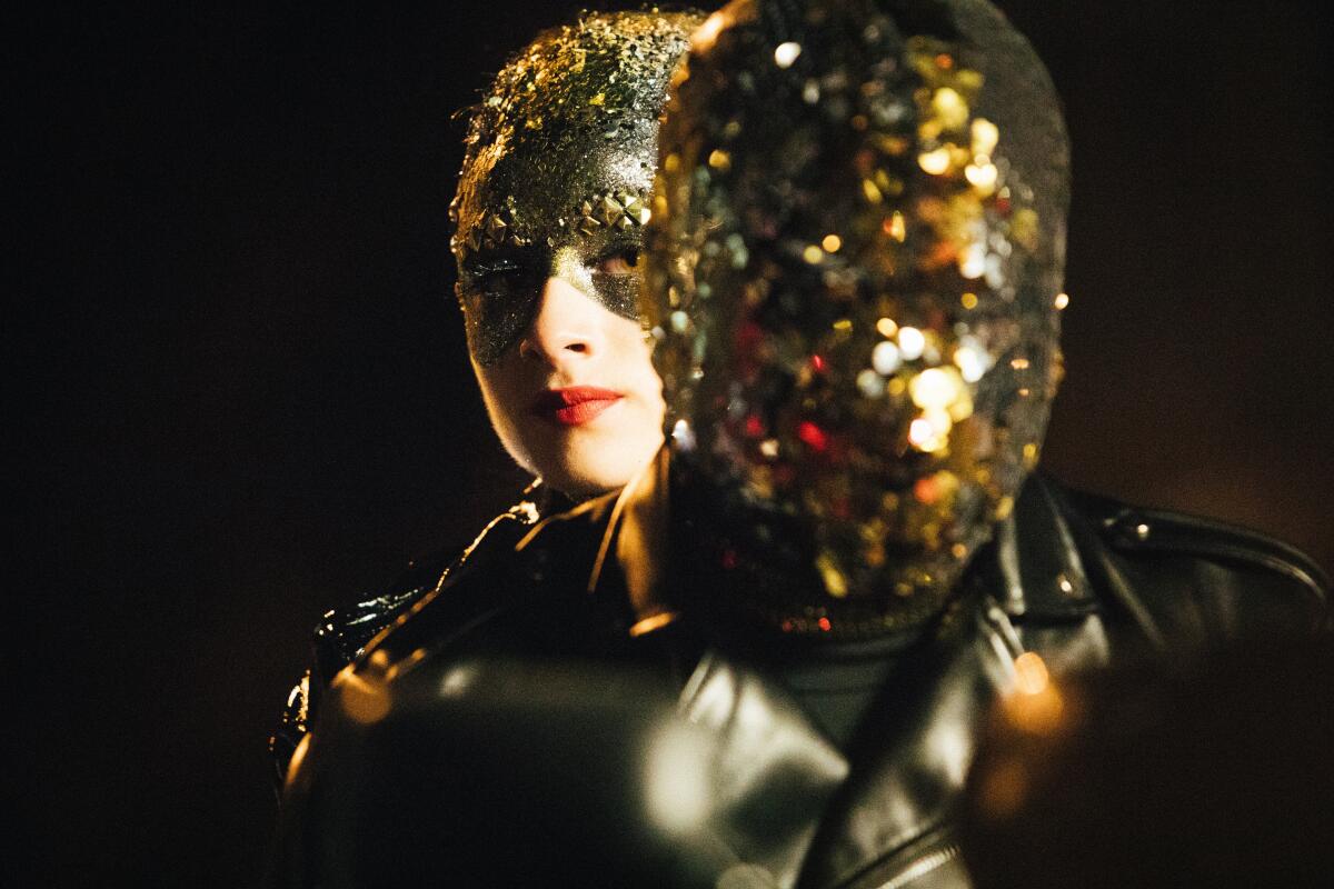 A woman performs in a sparkly outfit.