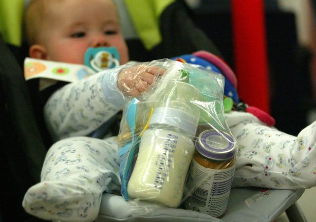 Image of baby holding plastic baggie of baby milk and food