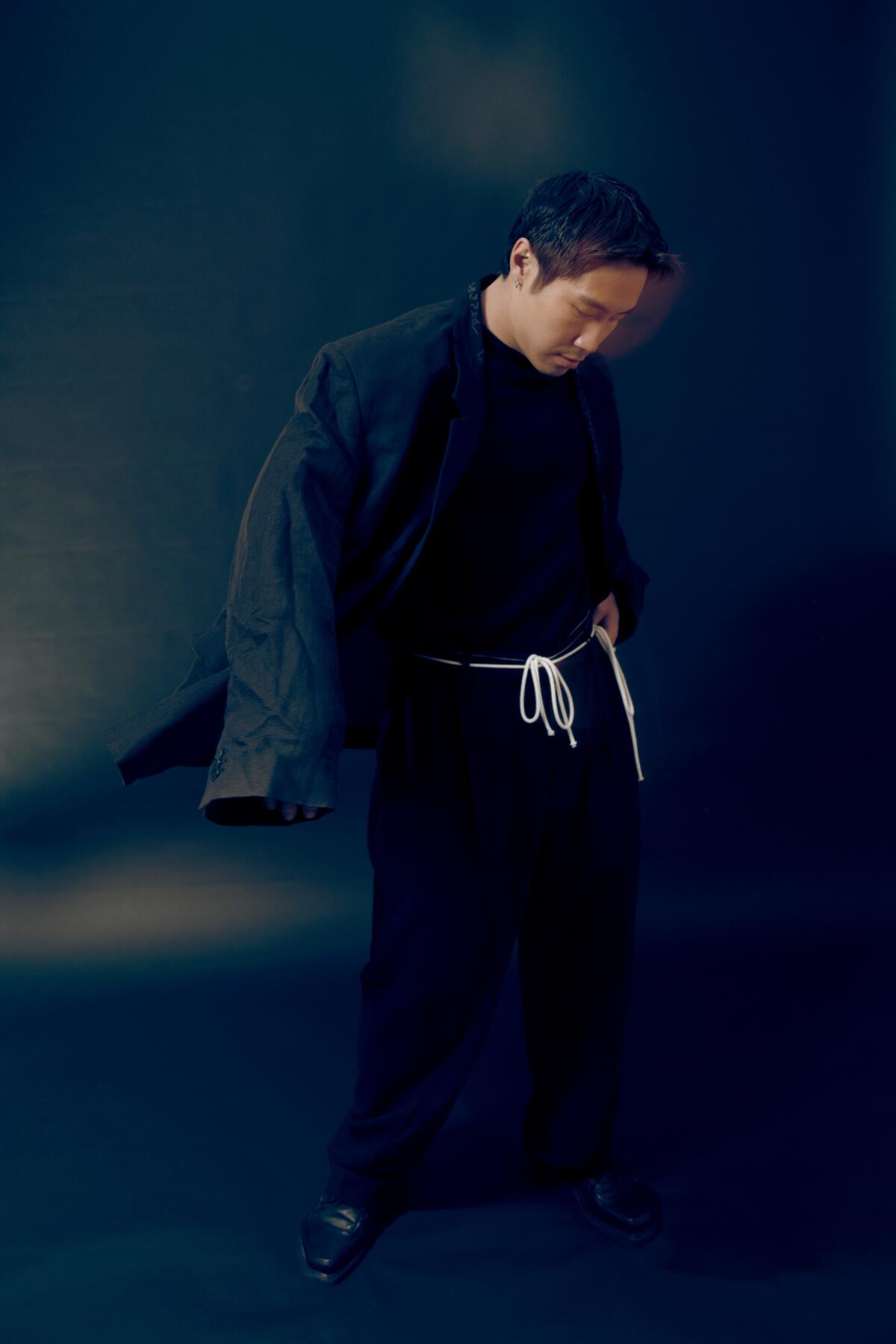 Young Mazino looks at the floor while standing