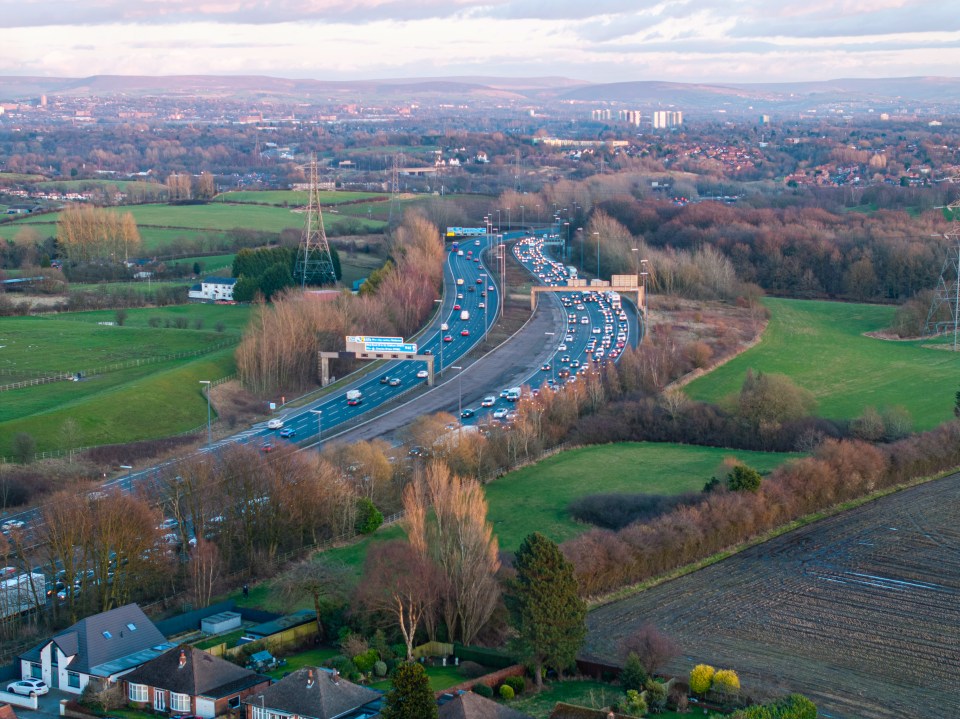 Aerial view of the M60 Outer Ring Road near Manchester, showing heavy traffic.