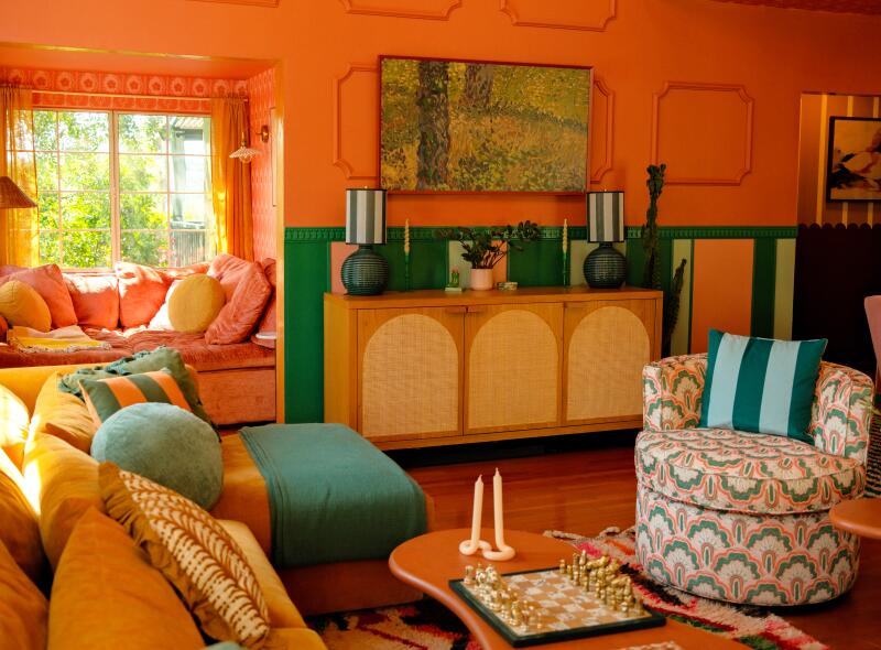 A coral and green living room with art TV on wall