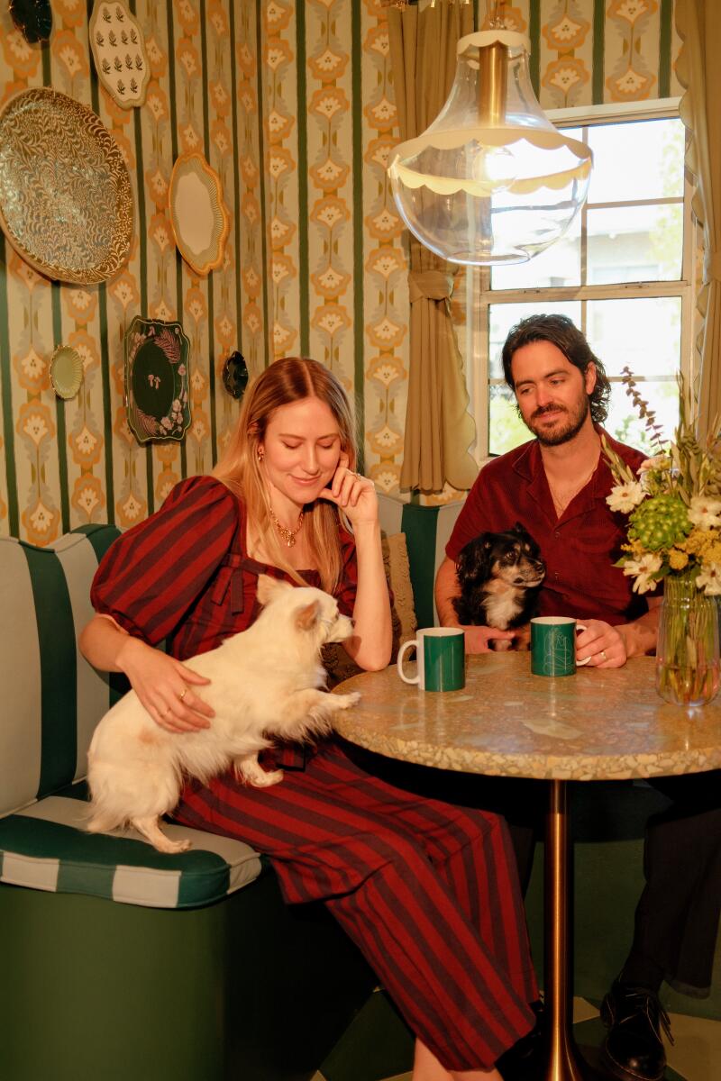 Dani Dazey and Phillip Butler sit in their kitchen banquette with two dogs