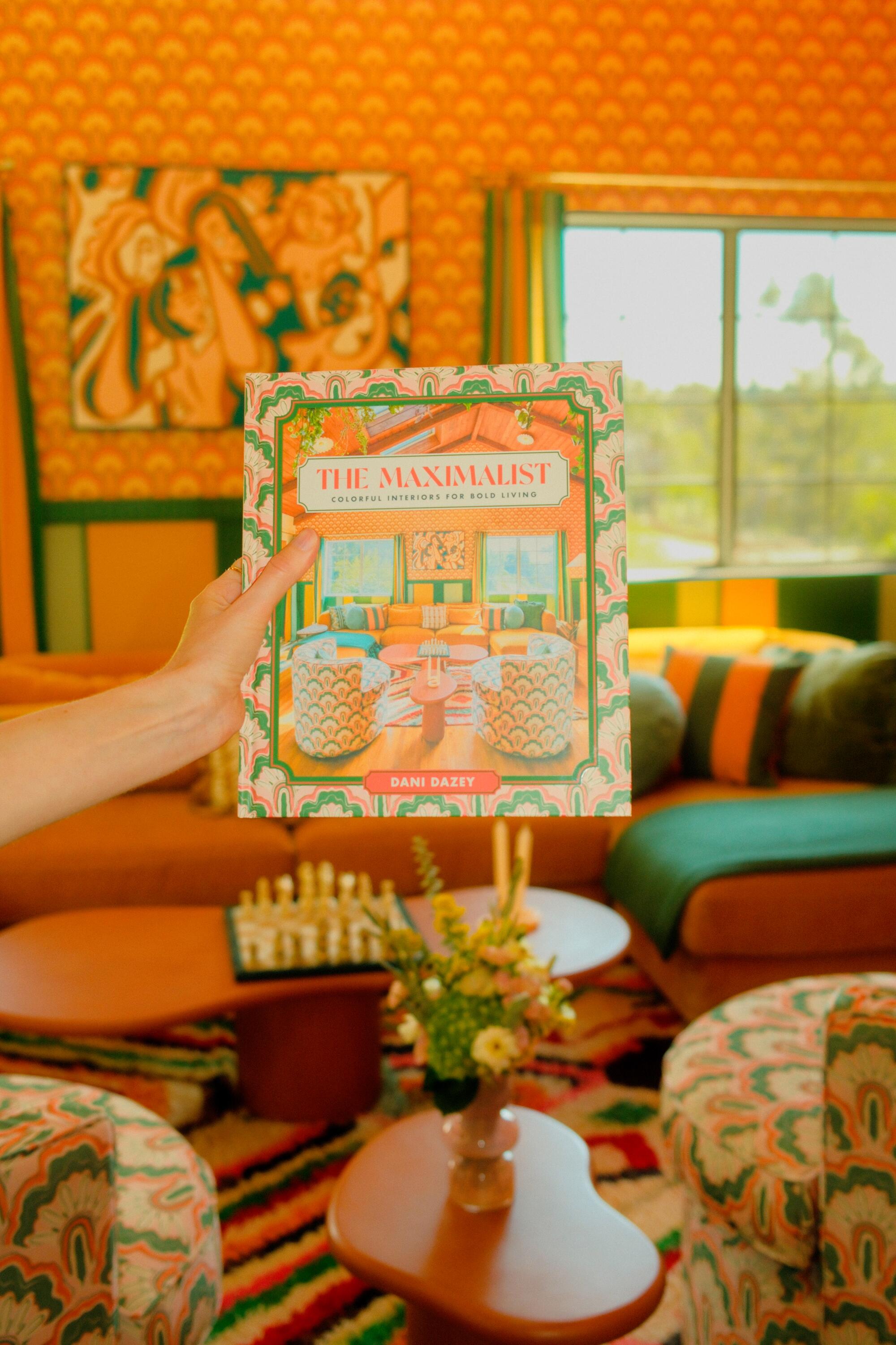 Dani Dazey holds her book "The Maximalist"
