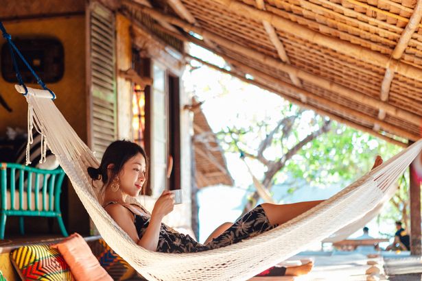 Young Asian woman enjoying a wellness treat on an Island. Concept of sustainable tourism and eco holiday.