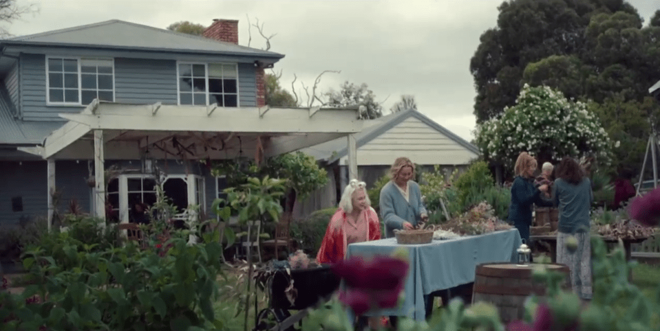Screenshot of people arranging flowers in a garden.