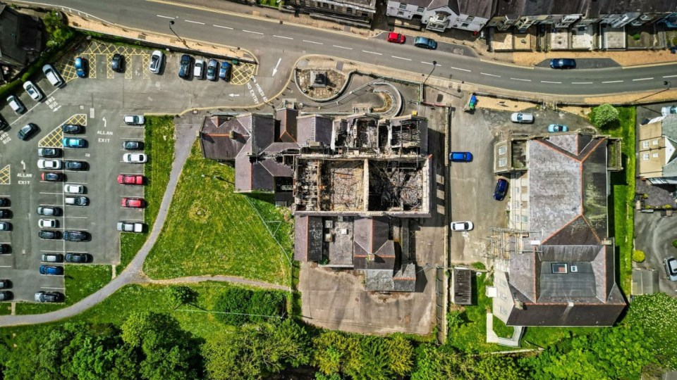 Aerial view of a fire-damaged Jacobean mansion for sale.
