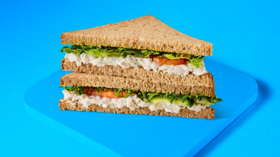 Double-decker chicken salad sandwich on whole wheat bread.