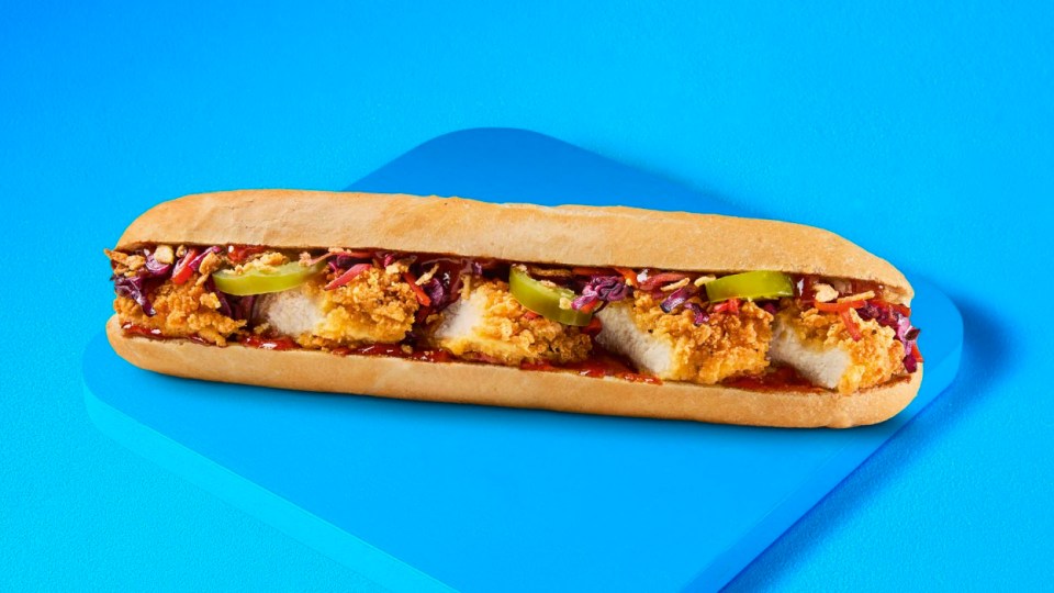 Crispy chicken sandwich on a roll with red cabbage and jalapenos.