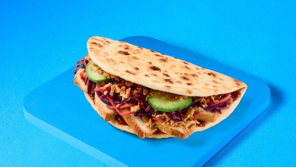 Flatbread sandwich with red cabbage, cucumber, and fried onions.