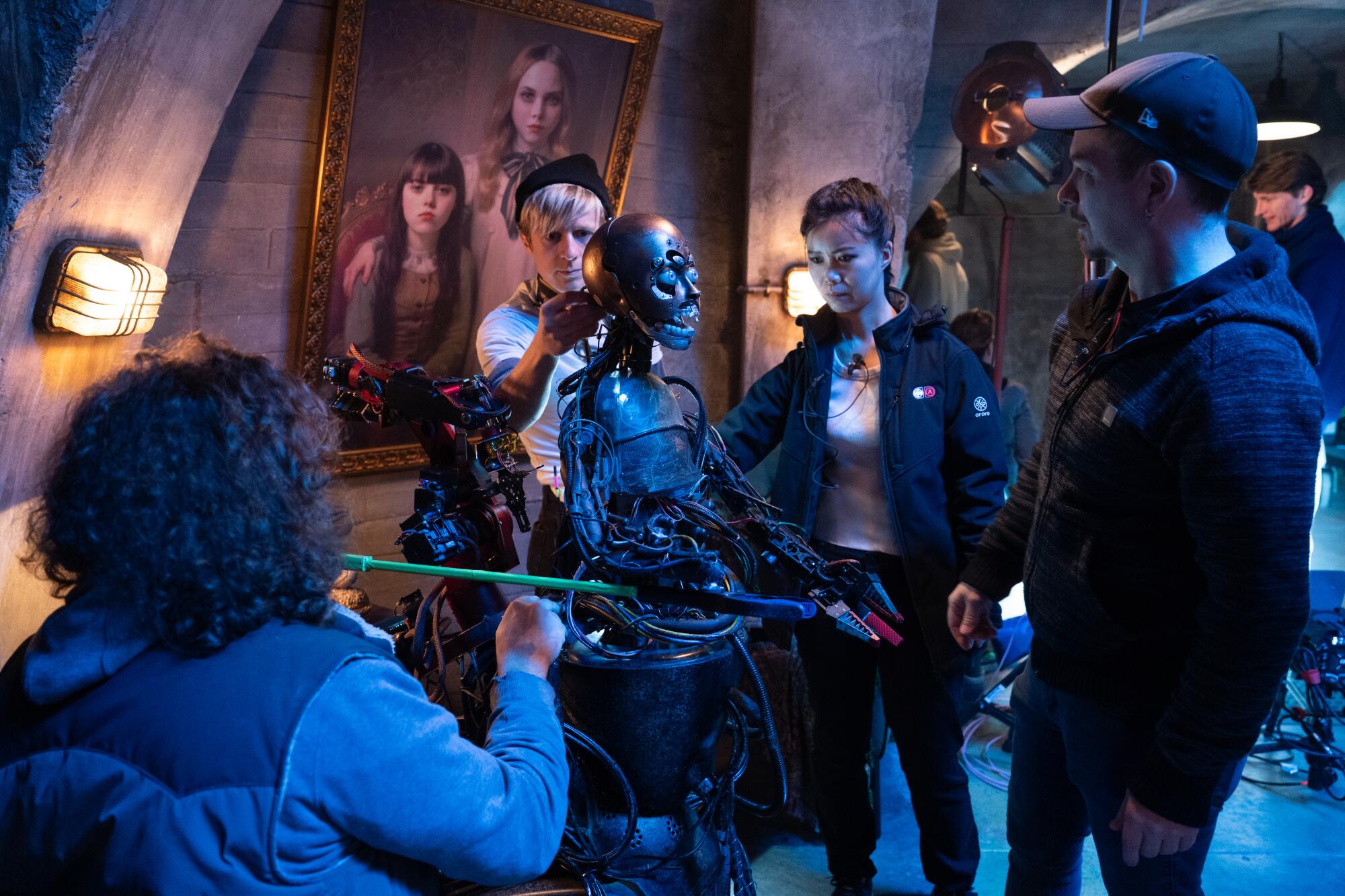 Designers prepare a metallic skeletal robot for action.