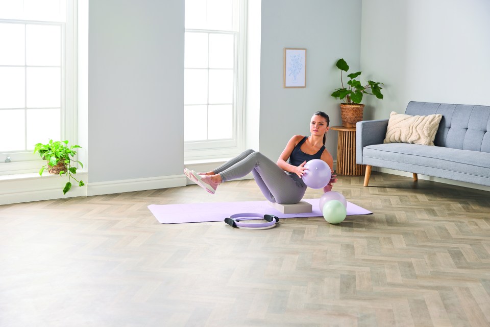 Woman doing Pilates with exercise ball and ring.