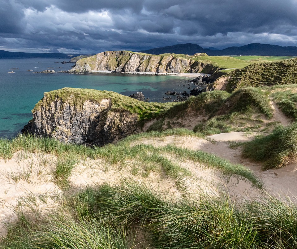 Sand dunes overlooking a coastal cove in Scotland.