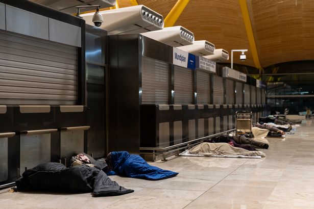 People sleep at a terminal of Adolfo Suarez Madrid-Barajas Airport on March 11, 2025 in Madrid, Spain