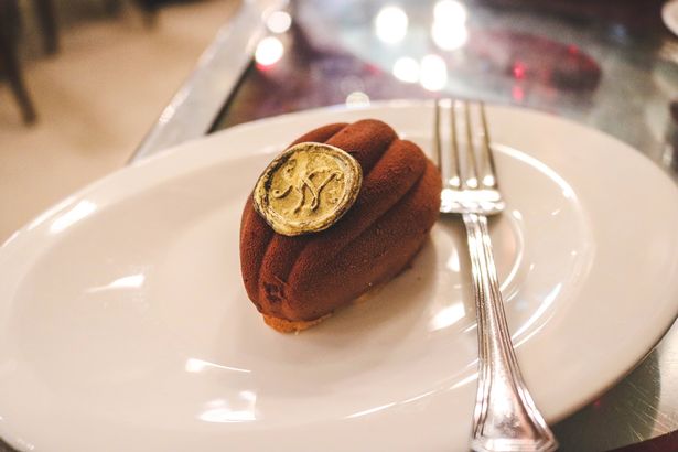A picture of a madeleine served on a plate and a fork 