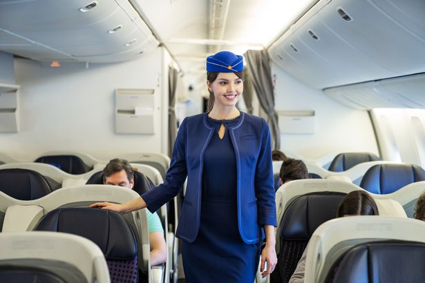 Image of flight attendant walking down aisle of plane