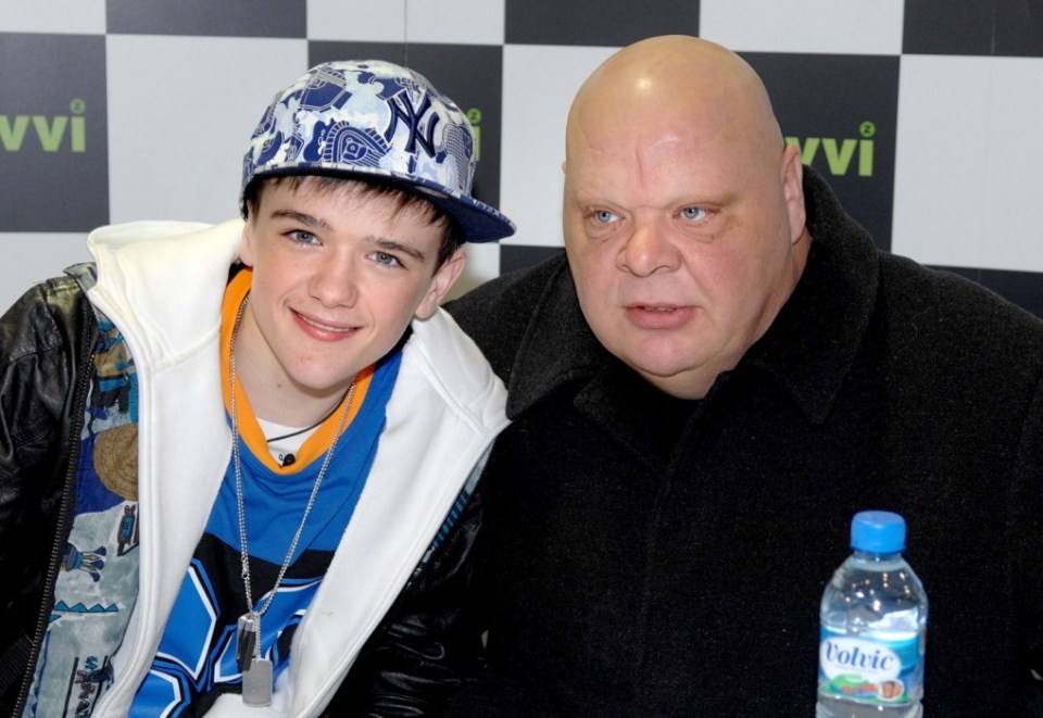MANCHESTER, UNITED KINGDOM - NOVEMBER 24:  George Sampson is protected by Simon Cowell's bodyguard Tony Adkins while signing copies of his new single 'Get Up On The Dance Floor/Headz Up' at Zavvi on November 24, 2008 in Manchester, England.  (Photo by Shirlaine Forrest/WireImage)