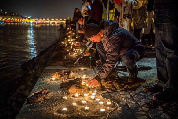 People lay candles and shoes at the bank of the Danube river during a rally in support of Israel in Budapest, Hungary, on October 10, 2023. Fighting between Israel and Hamas has entered a fourth day following the massive assault from Gaza by the Palestinian militant group on October 7, and as death toll mounts on both side. (Photo by FERENC ISZA / AFP) (Photo by FERENC ISZA/Afp/AFP via Getty Images)