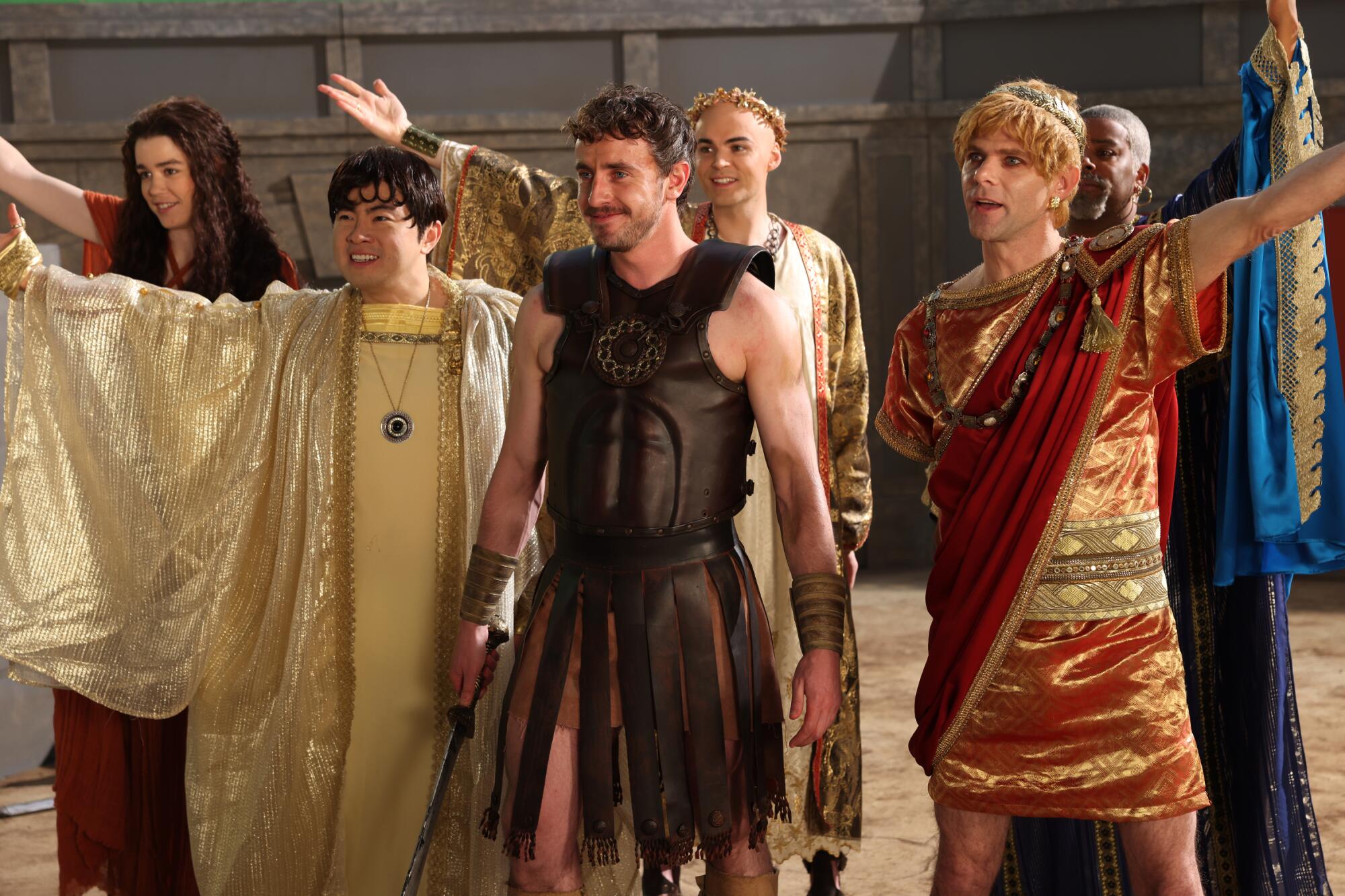 A group of people dressed in yellow and red robes of ancient Greece.