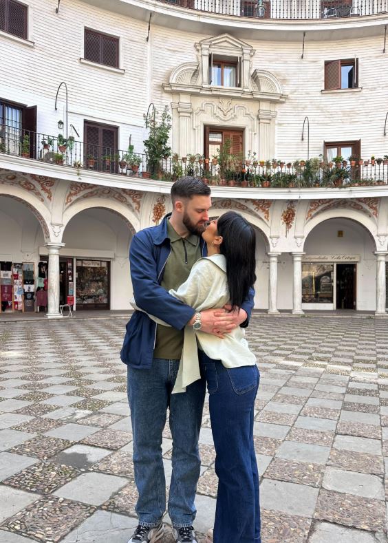 Couple embracing in a courtyard.