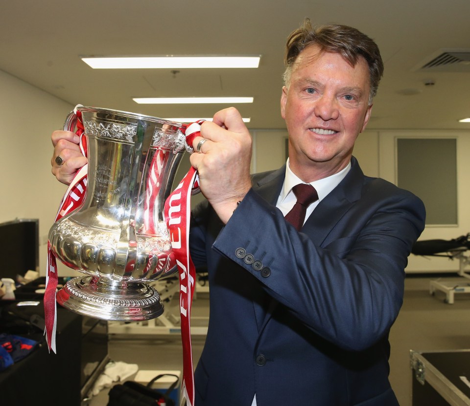 Louis van Gaal holding the FA Cup trophy.