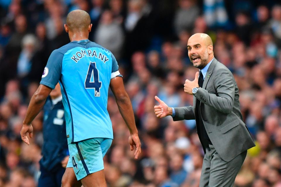 Pep Guardiola giving instructions to Vincent Kompany during a soccer match.