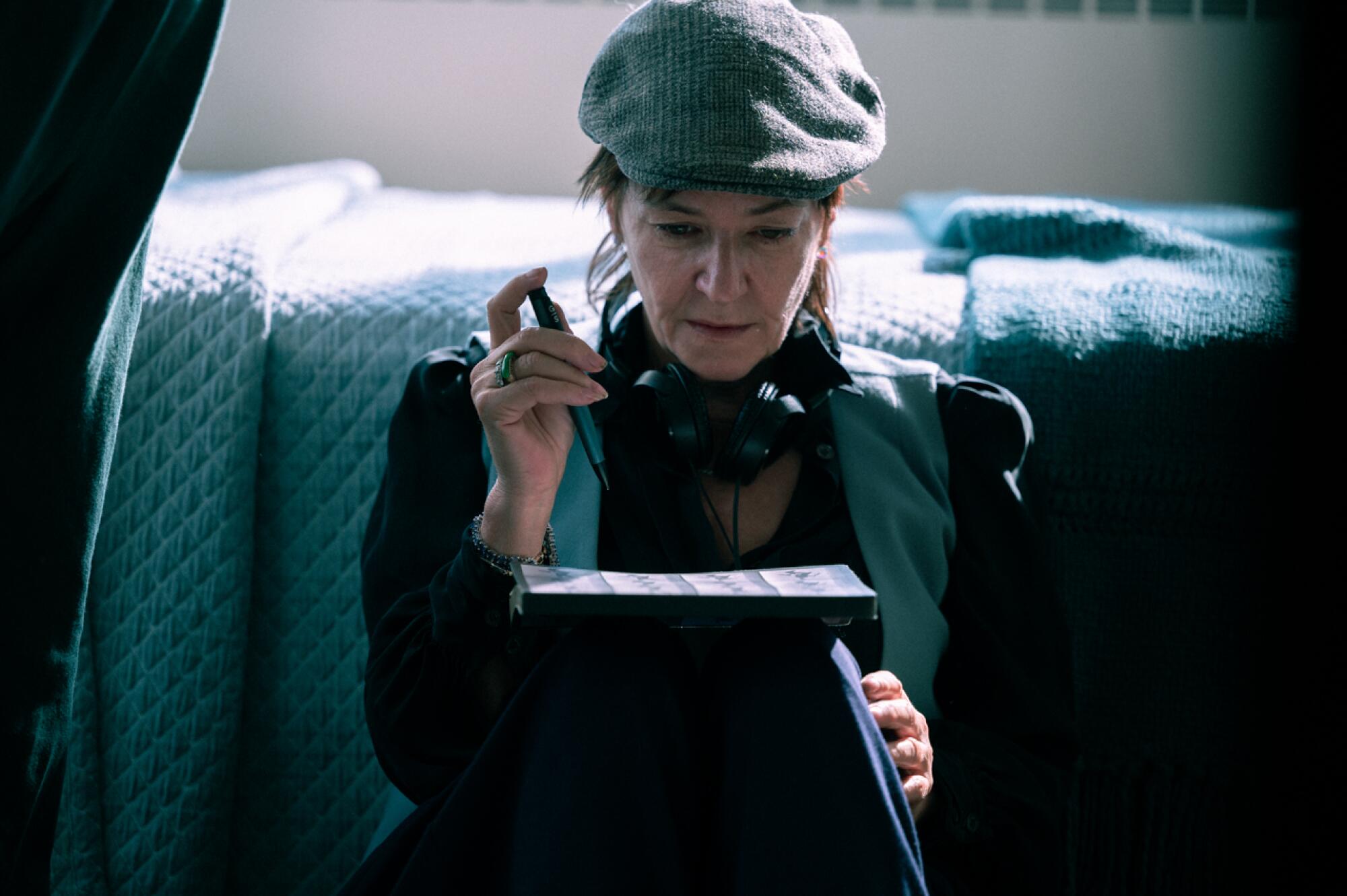 A director on a set studies images in between takes.