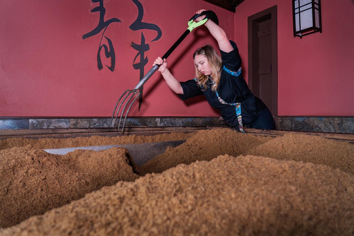 Attendant Samundra Sutcliffe churns the cedar enzyme shavings at Osmosis Day Spa Sanctuary.