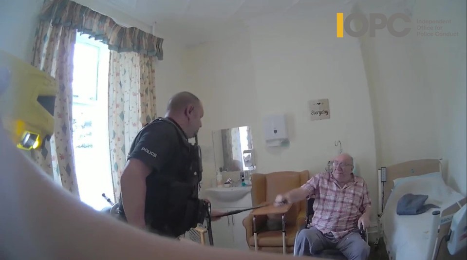 Bodycam footage of police officers interacting with an elderly man in a wheelchair.