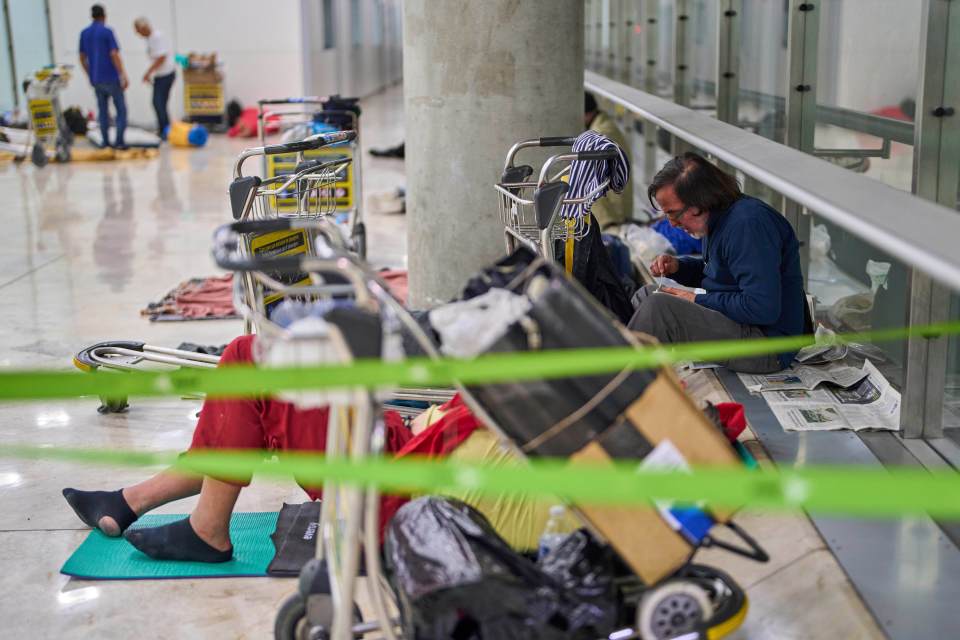 Homeless people sleeping on the floor of an airport terminal.