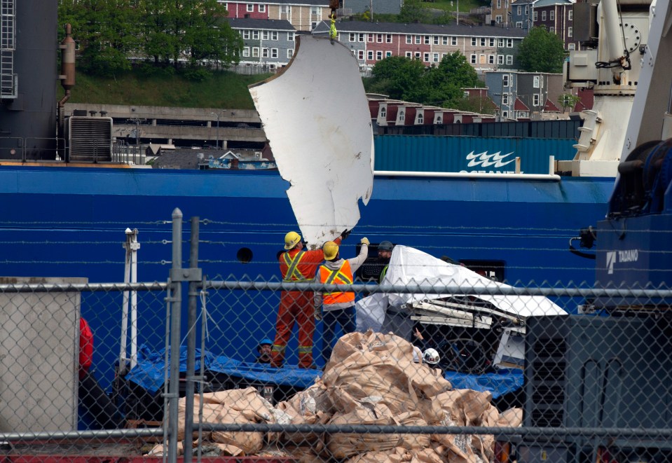 workers are working on a large blue ship with the letters eee on the side
